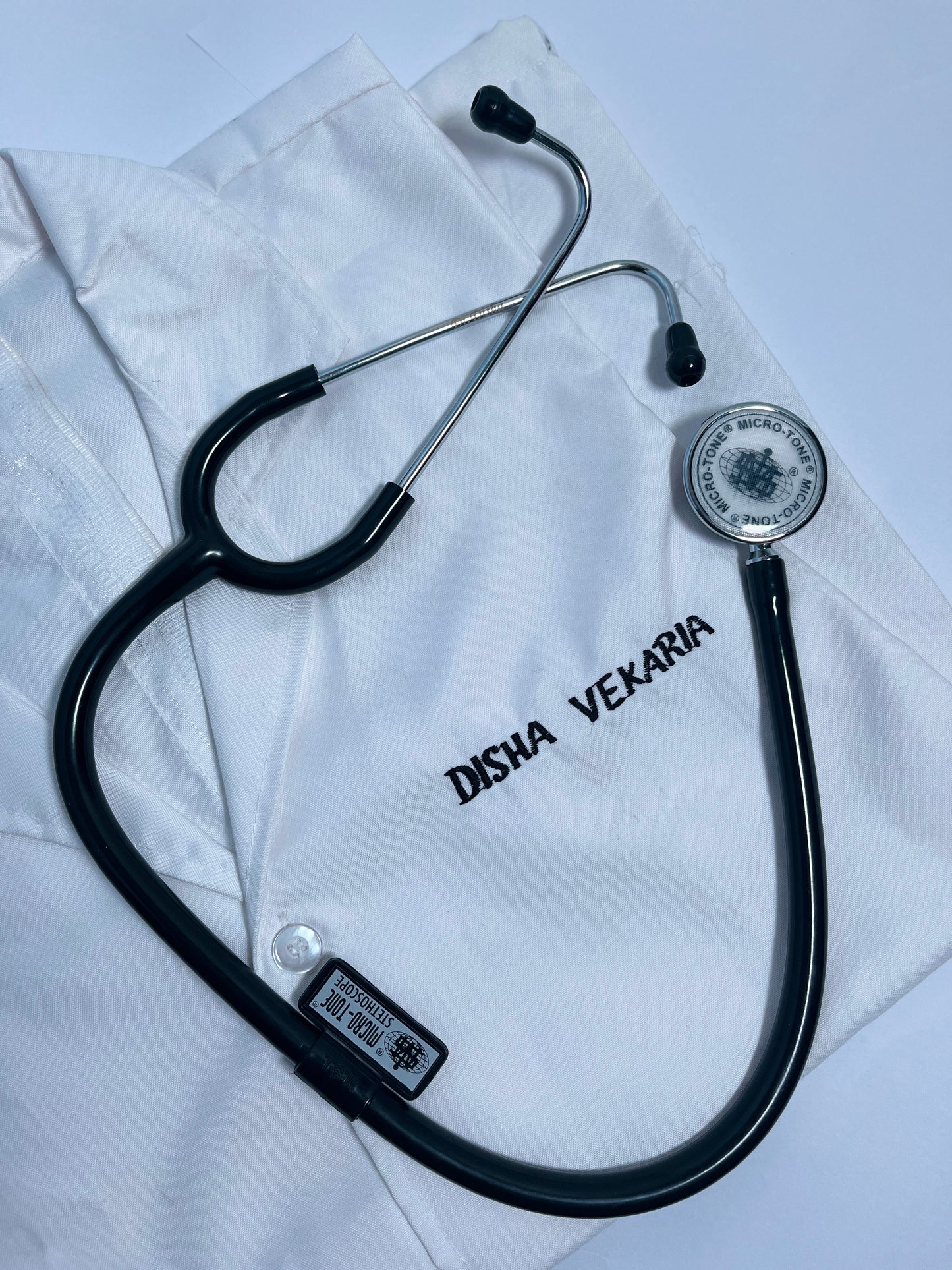 Stethoscope on a white coat with 'Disha Vekaria' branding.